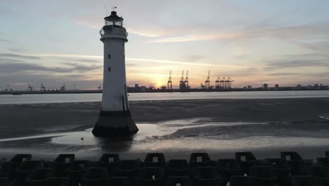 aerial view across dramatic golden hour british lighthouse at sunrise rising left orbit