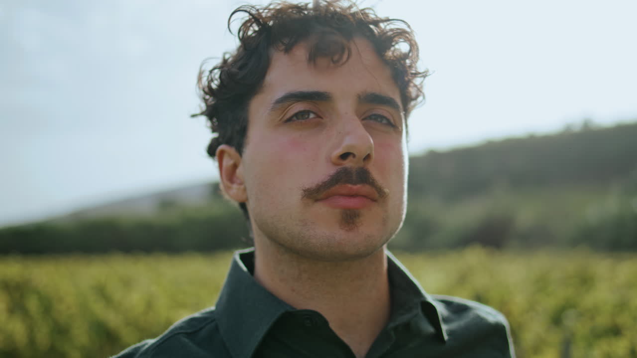 vinetero degustando vino blanco en copa de cristal de pie en el viñedo de cerca.