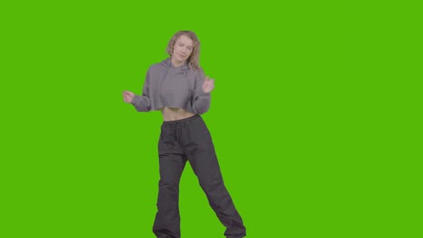 studio shot of young woman having fun dancing against green screen 25