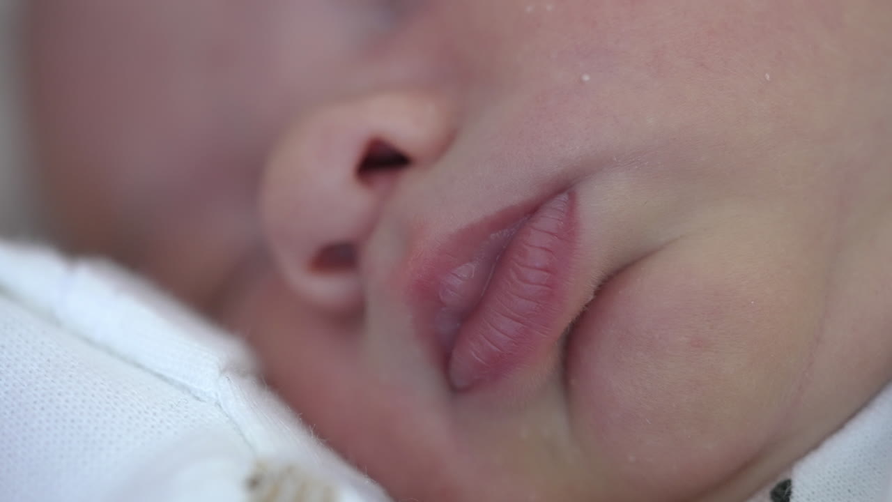 Face of a newborn child. Lovely small nose and mouth of a toddler while sleeping. Infant sleeps. Macro shot.