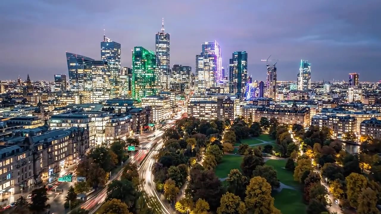 Una vivace serata urbana: il passaggio dal crepuscolo alla notte in un affollato centro città, illuminato da luci brillanti e con viste panoramiche sul parco.