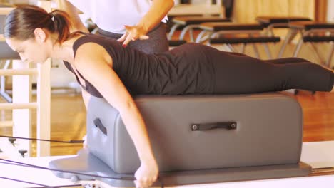 female trainer assisting woman with exercise