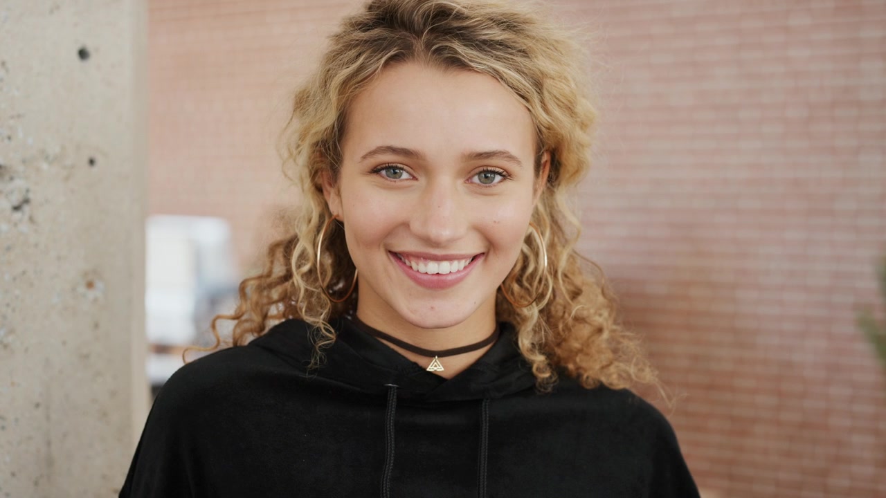 Portrait of a Smiling Young Woman with Curly Blonde Hair
