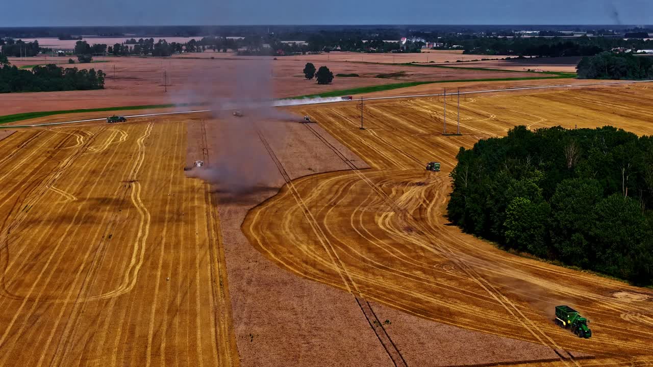 Timelapse aerial of farmland tractor combine harvesting, visible crop lines and rapid vehicle motion offloading grain