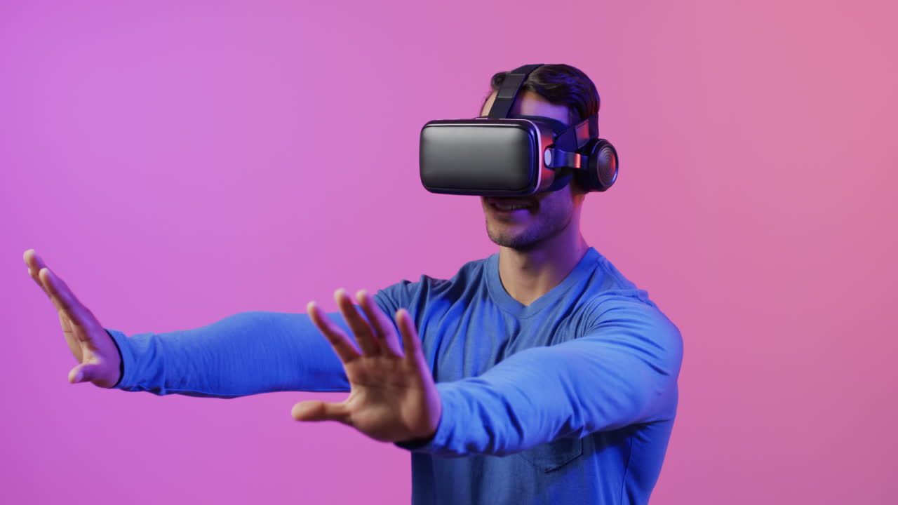 video di un uomo caucasico che usa le cuffie vr su sfondo rosa e viola