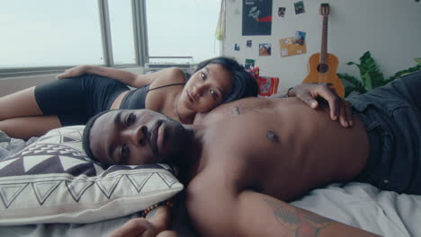 young couple resting in bed and posing for camera