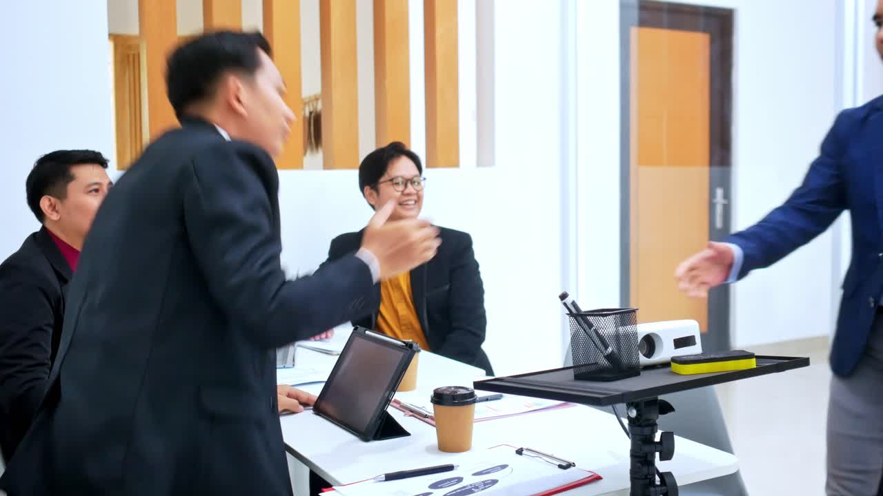 Diverse business team shakes hands before meeting in modern office