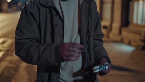 man holding something in his hand at night