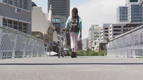 hombre de raza mixta caminando con una bicicleta