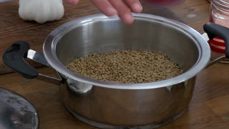 adding salt to a pot of lentils and hand stirring before soaking