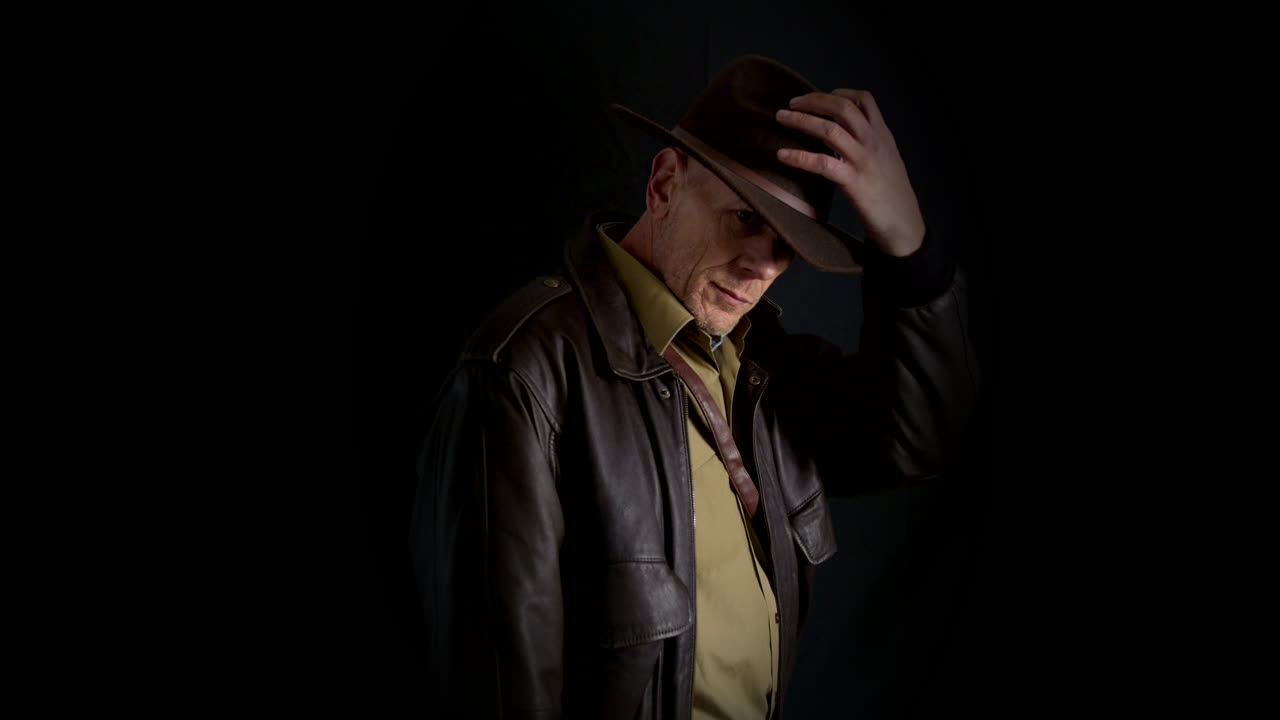 인디애나 모험가 무덤 습격자 탐험가 페도라 모자와 가죽 재 ⁇ 으로 카메라를 향해 돌아