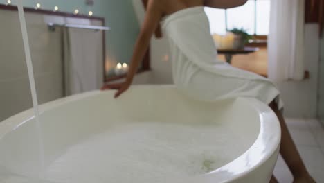 mixed race woman running a bath