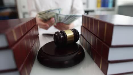 judge or lawyer counting banknotes in front of judge gavel at table