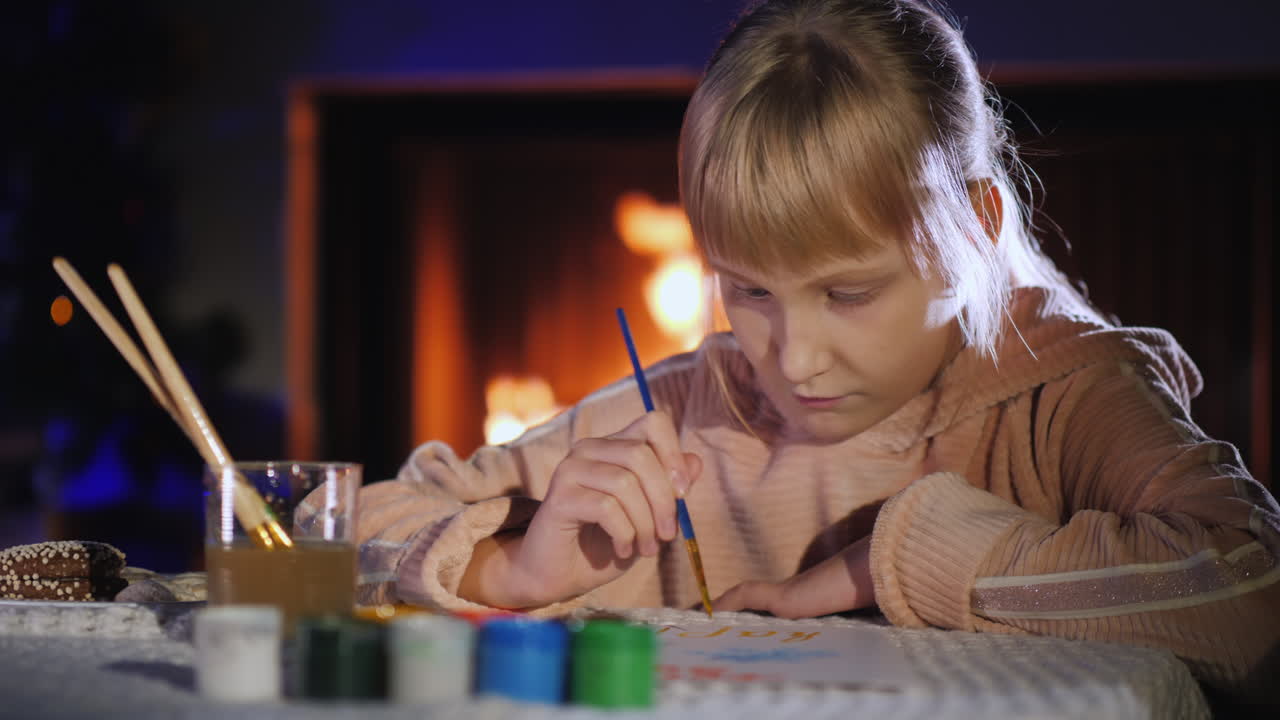 아이는 벽난로와 크리스마스 트리 근처에서 산타 클로스에게 편지를 씁니다.