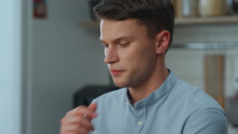 closeup young man thinking about job task sitting in kitchen. freelancer working