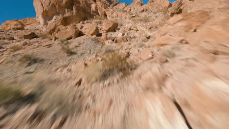 fpv drone flying through desert landscape on a sunny day