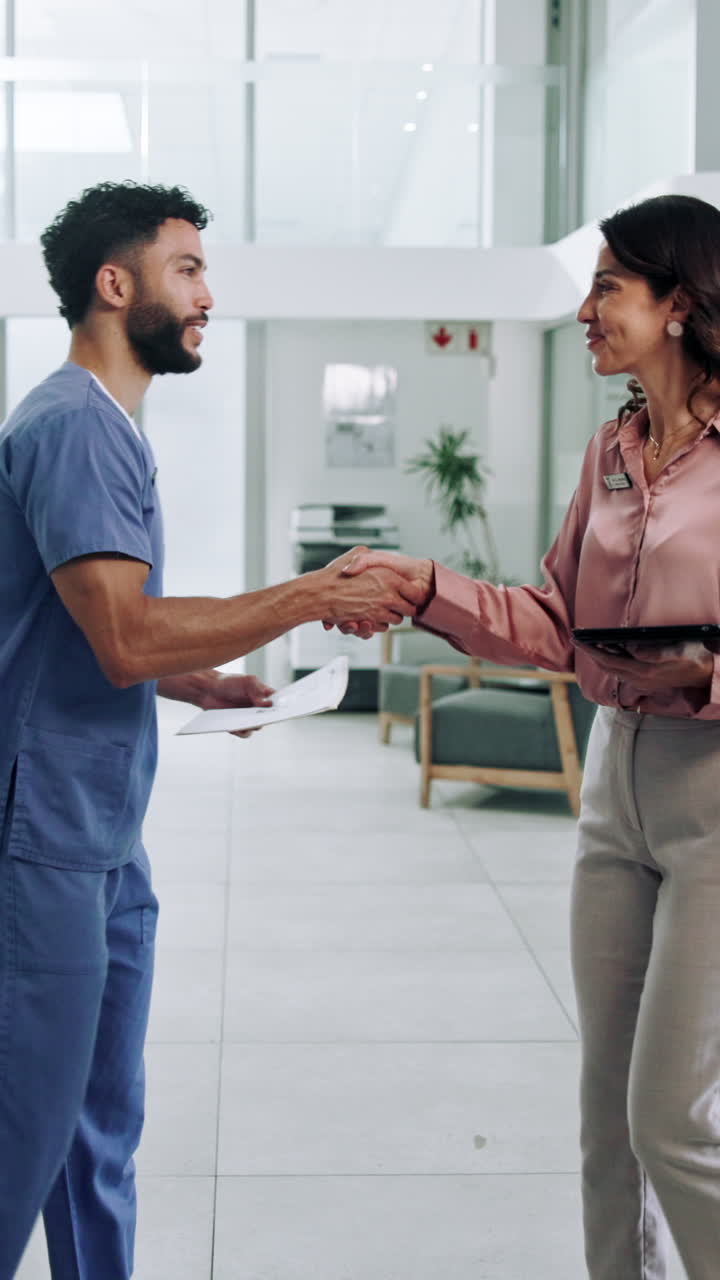 Professionisti del settore medico che si stringono la mano e discutono di documenti in ospedale