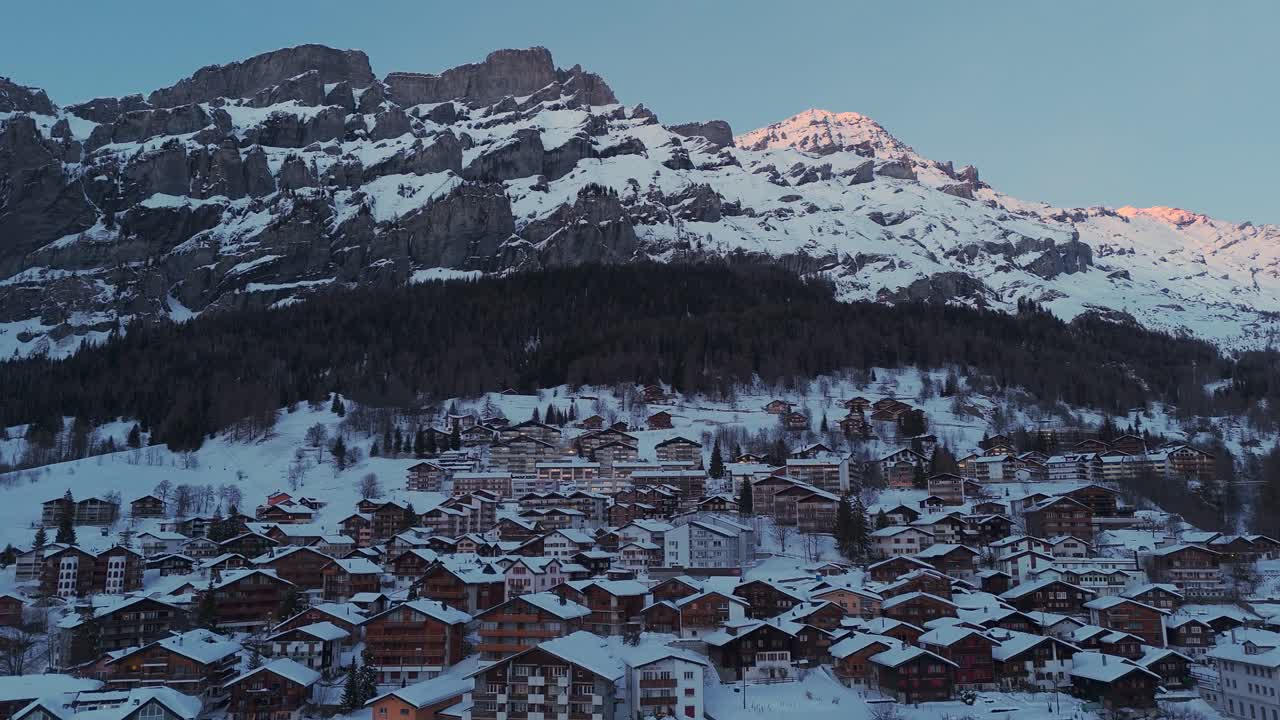 드론이 루이커바드의 작은 겨울 마을을 날아다니고 있습니다. 겨울이고 모든 것이 눈으로 가득 차 있습니다. 해가 지고 있습니다. 산의 꼭대기만 밝습니다. 크리스마스 겨울 풍경.
