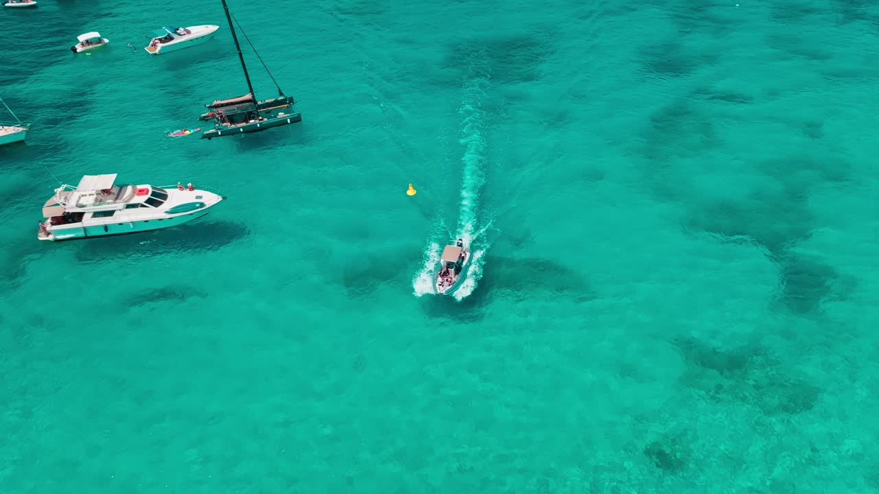 vista aérea de barcos flotando pacíficamente en aguas azules cristalinas