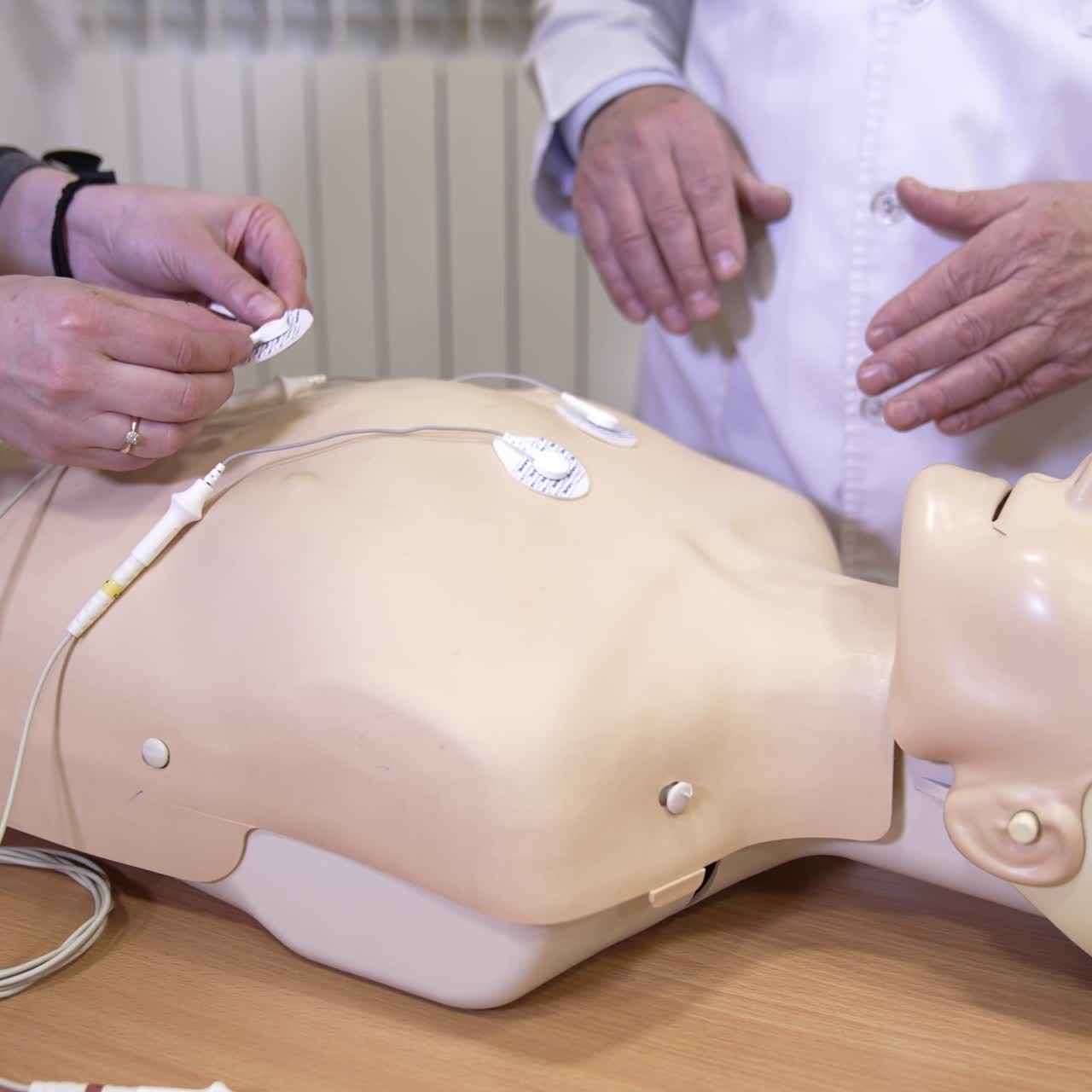 First aid training dummy. Demonstrating chest compressions on CPR doll in the class