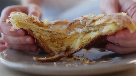 Croissant-Mit-Mandelgeschmack-Im-Coffeeshop-Zerreißen