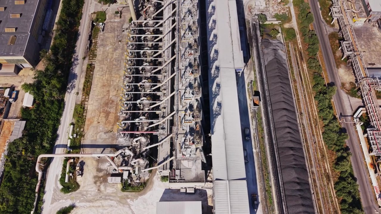 Grande sito industriale con sabbia e attrezzature in un'area di lavorazione.