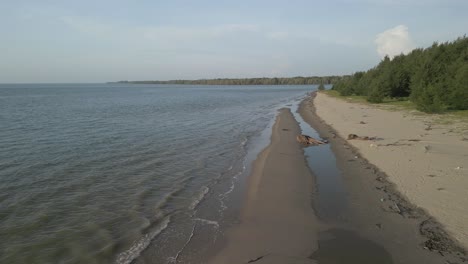 aerial drone view during summer gerigat fishing village,kabong with, facing open blue sea, white sandy beach,green coconut, palm trees,and river,sarawak,borneo