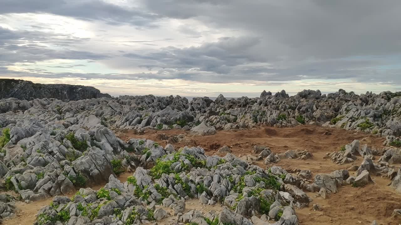 Rocky coastal cliffs with blowholes in Asturias under a moody cloudy sky
