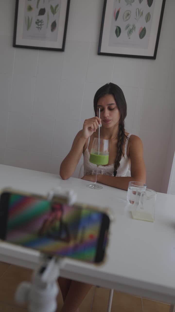 Woman filming herself drinking smoothie