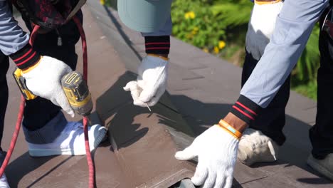 asian technician use electric drill to install roof tile, close up