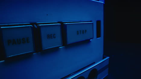 a close-up on a vintage tape recorder in a blue light