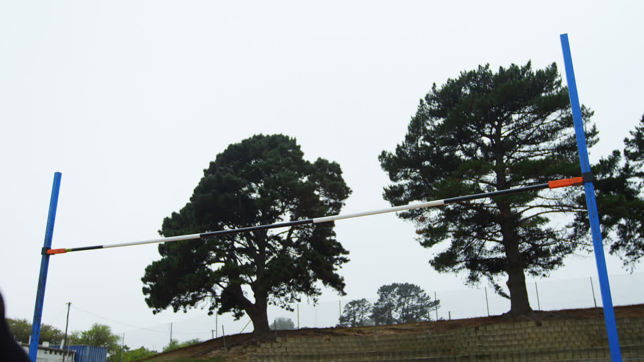 낮은 각도 뷰 백인 여성 운동 선수가 스포츠 장소에서 높은 점프를 연습합니다.