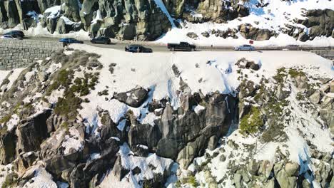 vista aérea de un gran acantilado debajo de la carretera de montaña con coches que pasan