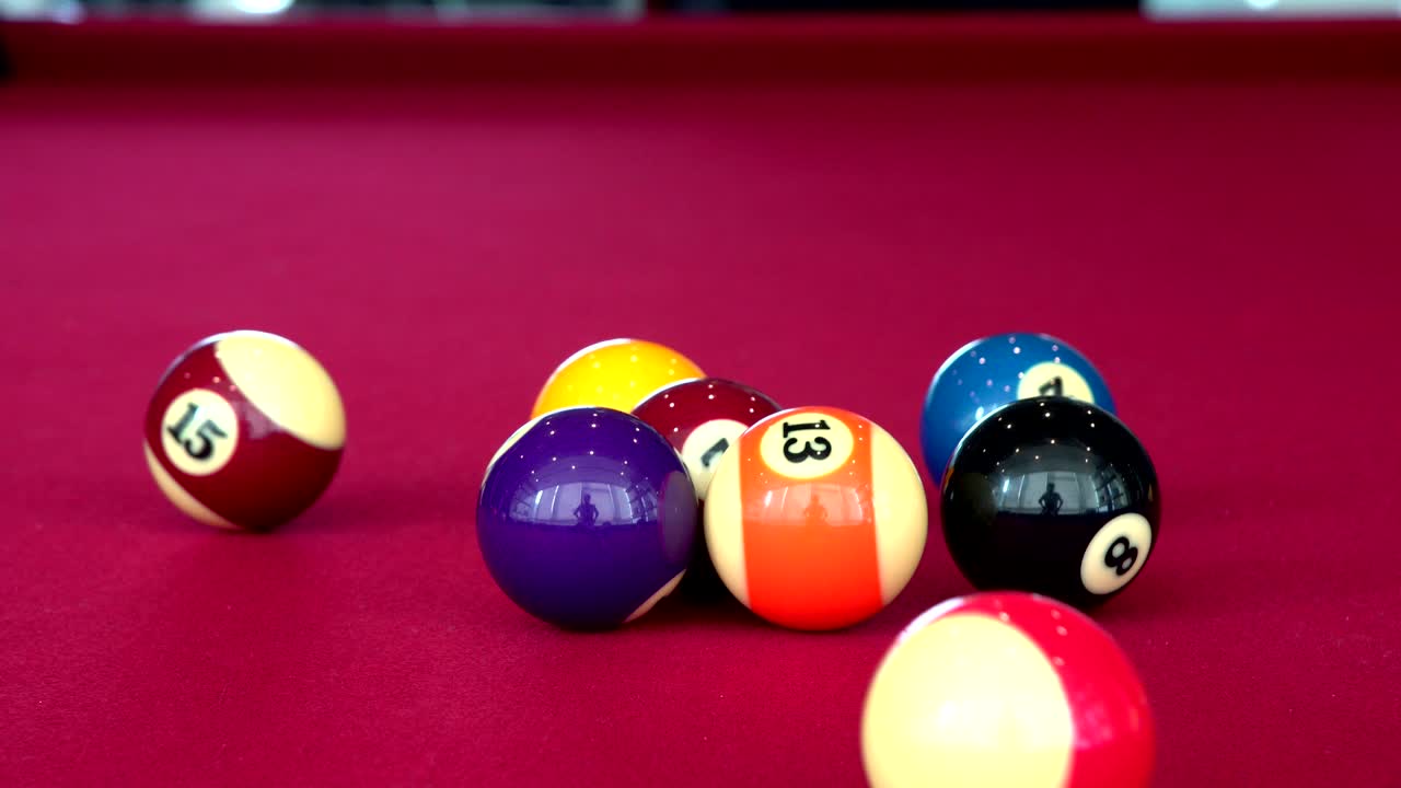 Playing the pool-billiard game on red baize table. This is sports