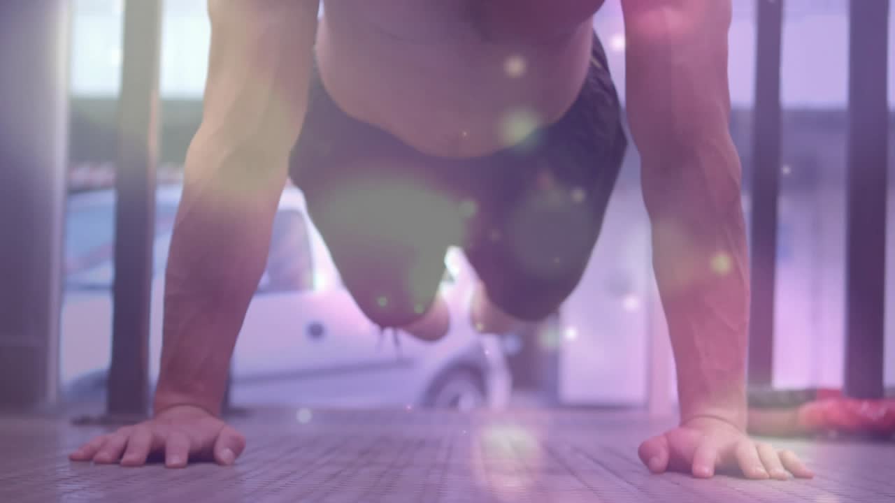 Uomo che fa flessioni partendo da posizione prona, abbassando il petto e spingendosi verso l'alto, sovrapposizione bokeh per il fitness