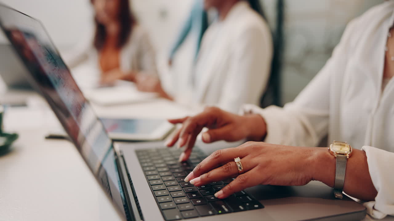 mujer escribiendo en la computadora portátil durante una reunión