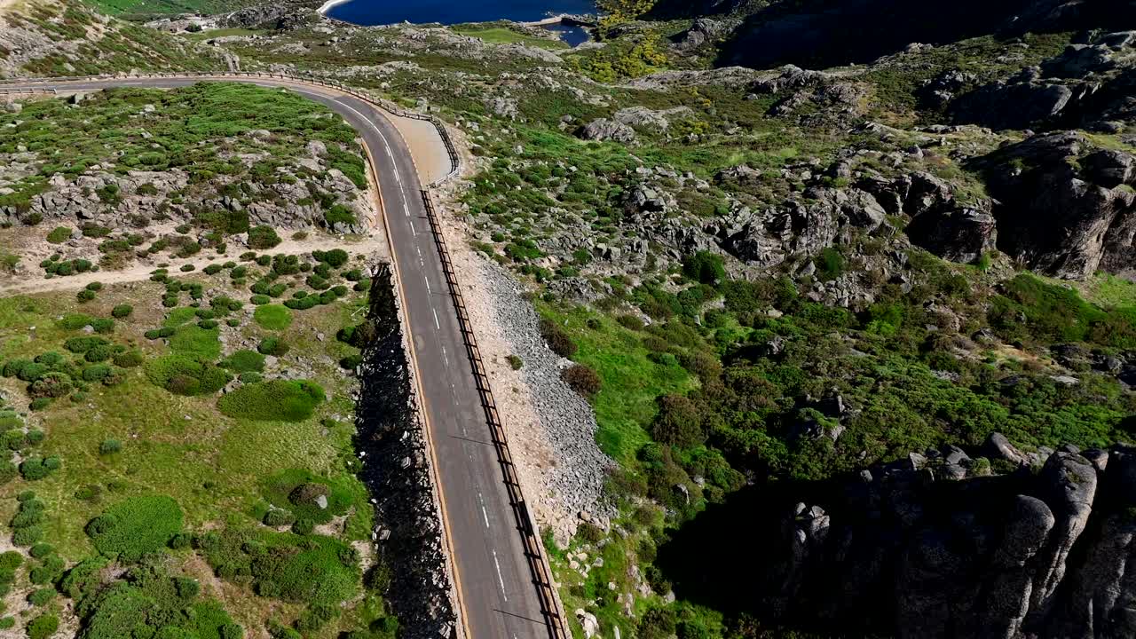 una vista aérea de una carretera sinuosa que conduce a una impresionante laguna en serra da estrela, portugal