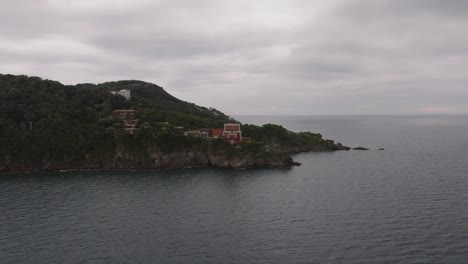 aerial forward to hotel resorts on a coastal cliff, island ischia in italy