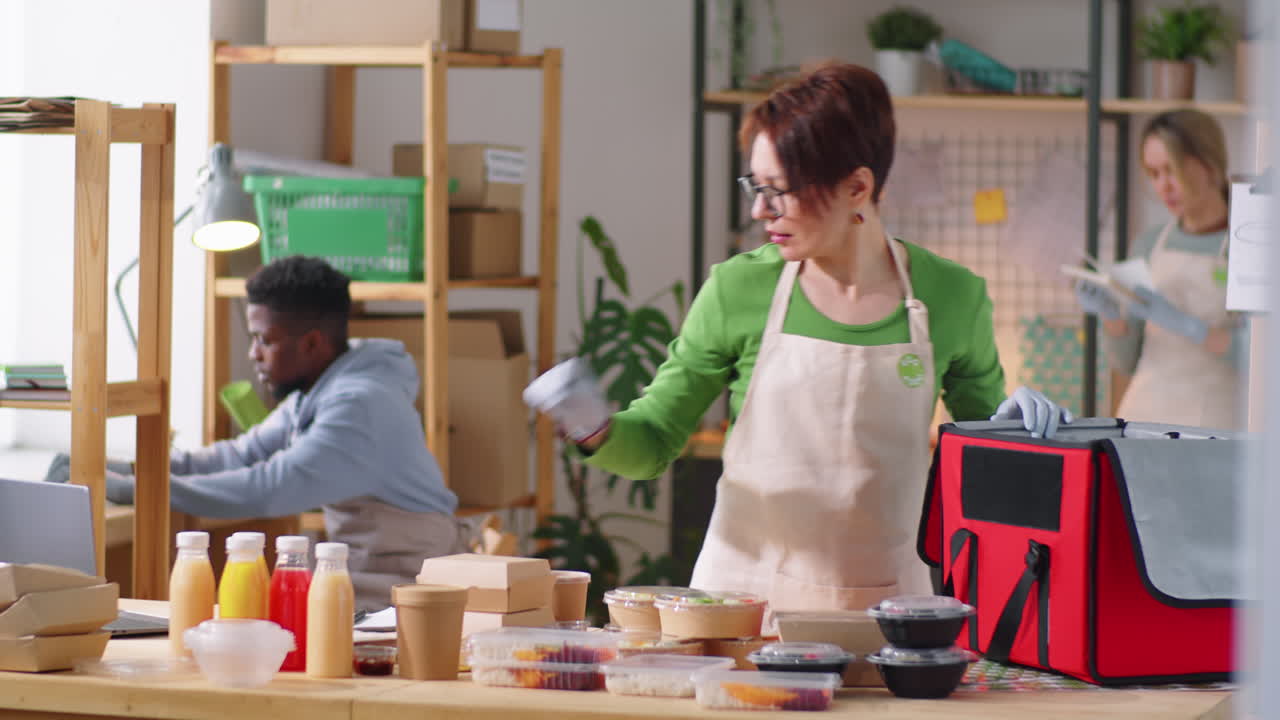 mujer empaquetando contenedores de alimentos en la bolsa de entrega