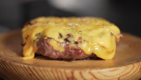 chef asando queso americano en una hamburguesa de ternera con un soplete de cocina