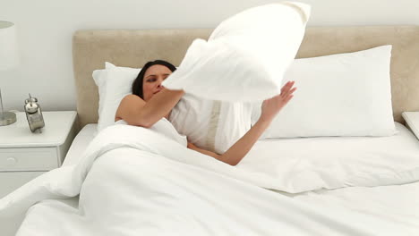 morena sosteniendo una almohada mientras duerme