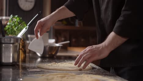 el chef preparando la masa de la pizza