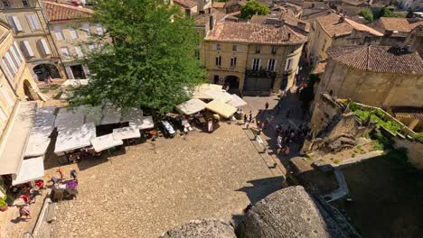 vista aérea de la bulliciosa plaza del mercado en saint-émilion