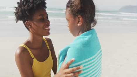 Afroamerikanische-Mutter-Trocknet-Ihre-Tochter-Mit-Einem-Handtuch-Am-Strand