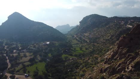 Toma-Aérea-De-Establecimiento-Con-Drones-De-Una-Aldea-En-El-Valle-Entre-Las-Montañas-De-Nepal-Durante-El-Día-Soleado.