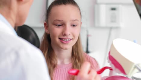 dentist showing the proper way of brushing teeth