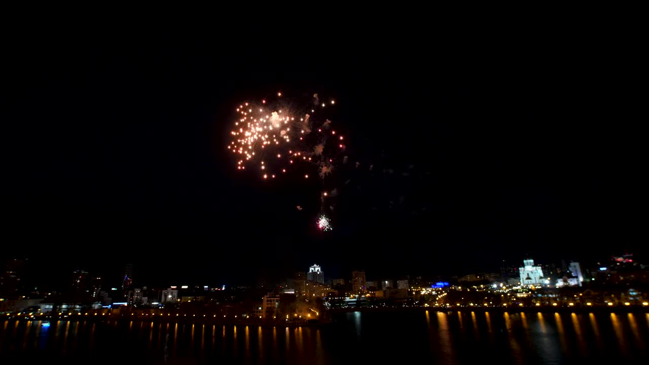 fuegos artificiales nocturnos sobre la ciudad junto al río