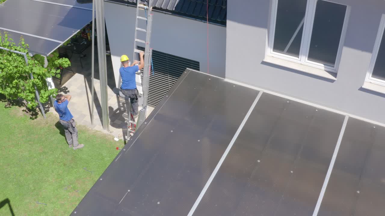 Workers climbing down a ladder from house roof. Break from work