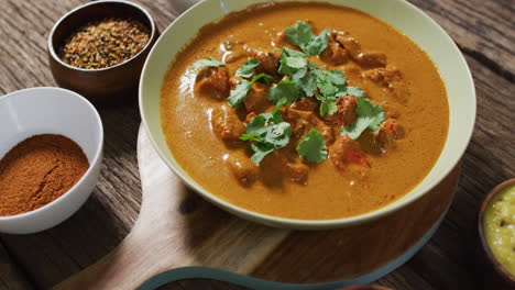 video of freshly prepared curry in bowl lying on board on wooden surface