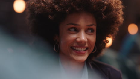 beautiful woman with afro hairstyle hanging out with friends in restaurant wingking playfully laughing enjoying socializing at party gathering